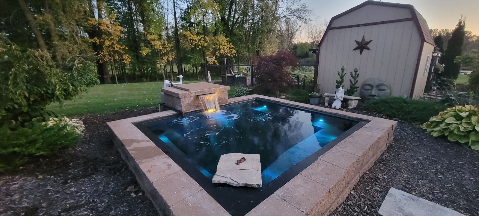 Closeup of newly created koi pond with fiberglass, resin and tile in backyard