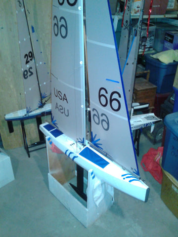 IOM RC Yacht made with fiberglass cloth and epoxy resin. White and blue sails and hull.